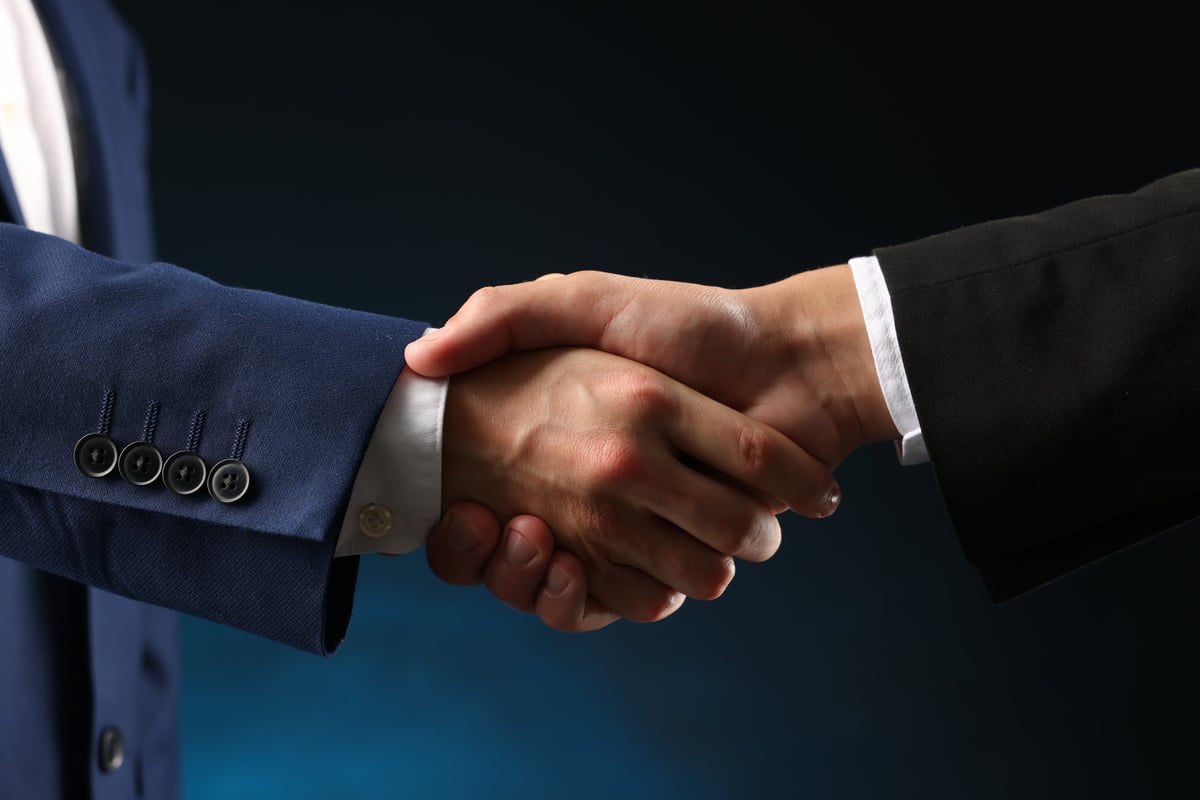 Two business partners shaking hands to confirm an agreement